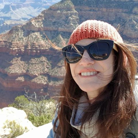 Julia Kerr Shares her Mental Health story for RUOK Day. Image: Selfie image mental health warrior woman Julia Kerr with brown hair, orange beanie and sunglasses smiling. The grand canyon is behind her.