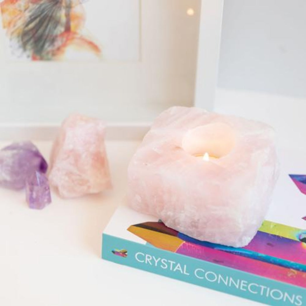 Candle Crystal Homewares Love  Rose Quartz Rough Cut. Pale Pink Square cut rose quartz crystal .  Sits on Crystal Connection Book from side view.  Contains light tealight with amethyst and rose quartz in background
