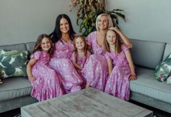 Two moms with daughters in matching pink loose-fitting boho dress