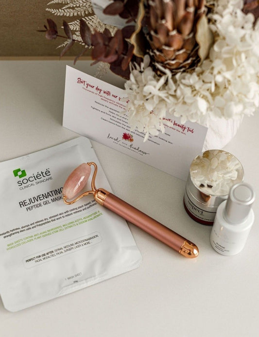 rose quartz face roller in rose gold beside rejuvenating facemask and face creams