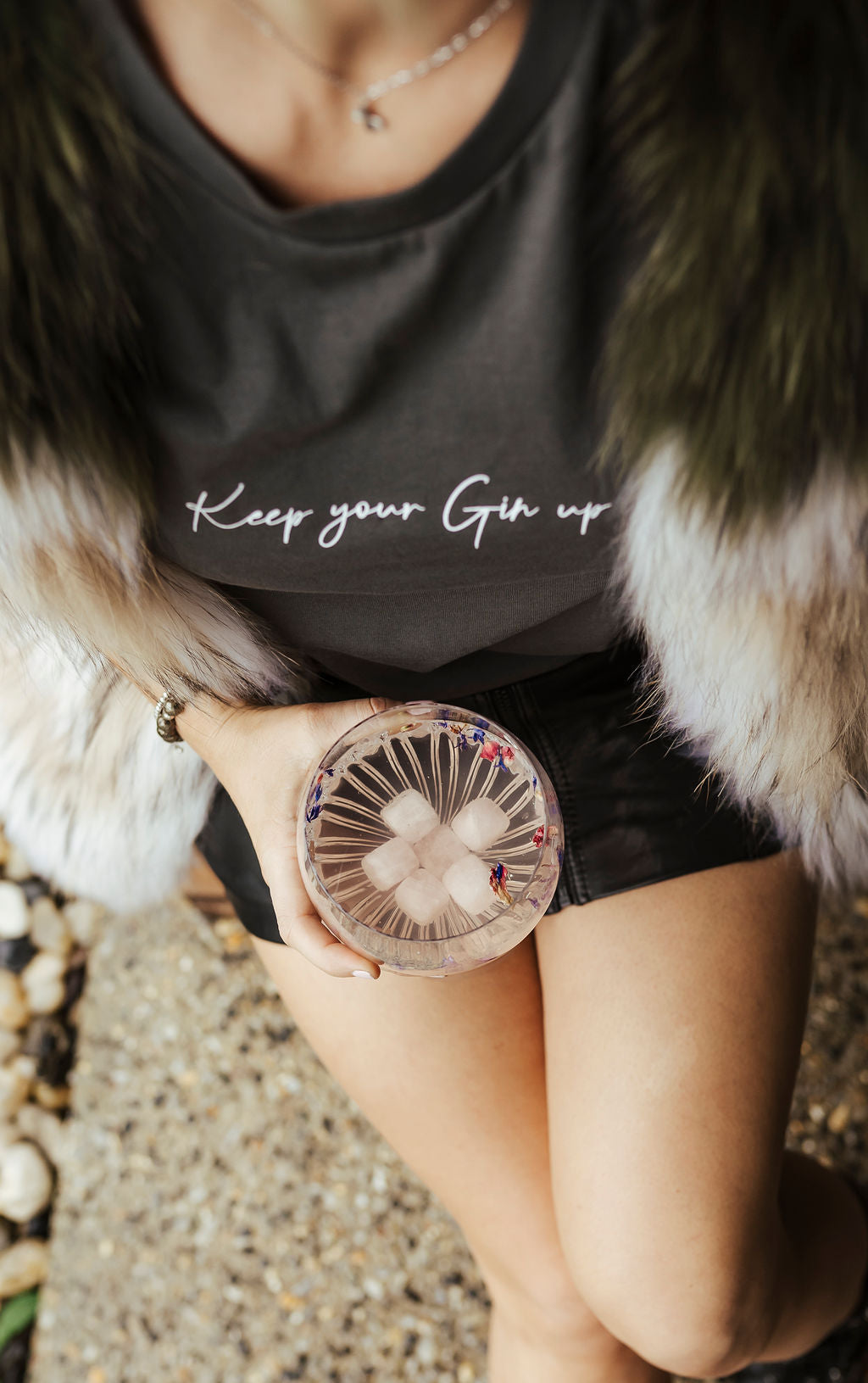 rose quartz gin stones in a glass of wine held by woman wearing Keep Your Gin Up shirt
