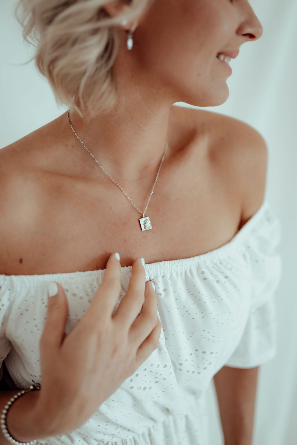 silver heart of lion necklace with square pendant when worn